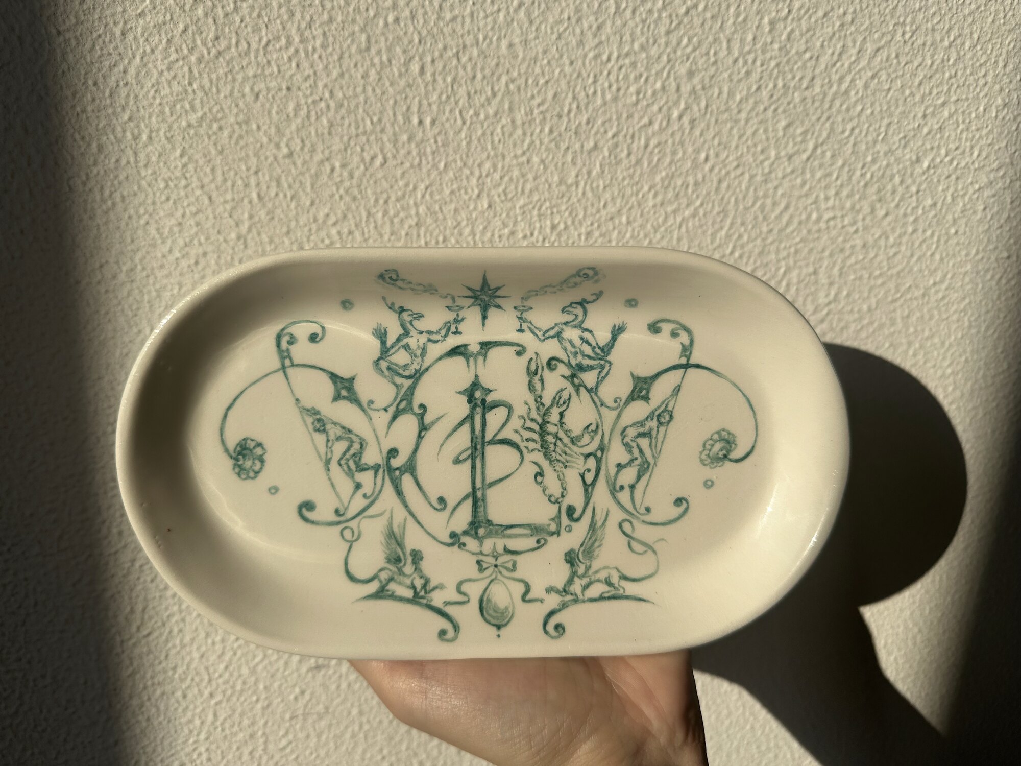 Oval ceramic dish painted with a monogram